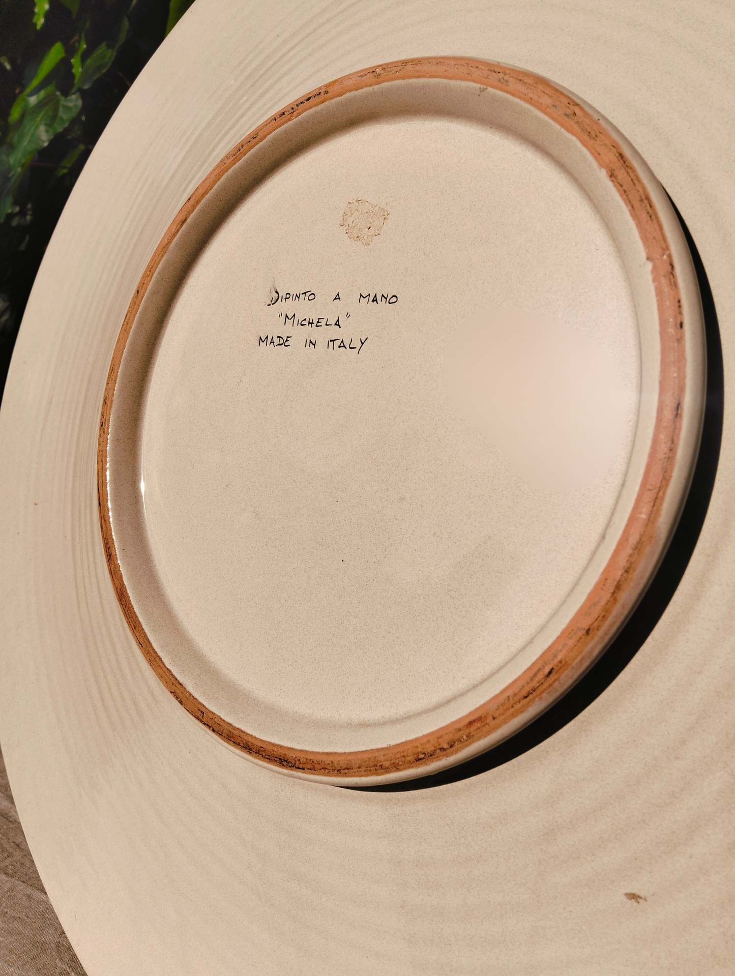 Back of the Large Deruta ceramic decorative plate Ø 61 cm, rich red floral motif, signed by artist Michela. 
This majolica charger plate is an authentic collectible piece, entirely hand-thrown and freehand-painted in the artisan workshops of Deruta, Umbria